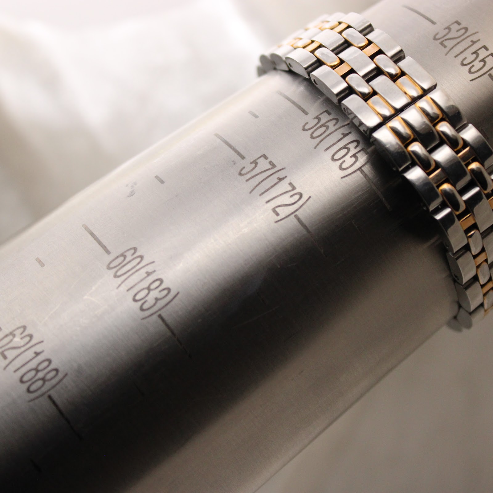 Close-up of the watch bracelet wrapped around a sizing gauge, indicating a wrist size of 165mm.