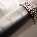 Close-up of the watch bracelet wrapped around a sizing gauge, indicating a wrist size of 165mm.