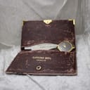 The Raymond Weil branded wallet opened, revealing the original documentation and partially showing the watch face tucked inside.