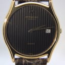 Close-up of the black vertical-striped dial, showing gold-tone hands, Raymond Weil Geneve branding, and the date display.