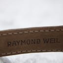 Close-up of the underside of the dark brown leather strap, revealing the embossed 'RAYMOND WEIL' branding.