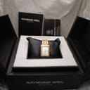Raymond Weil Tango watch nestled in its original black presentation box, with manuals and documents in the background