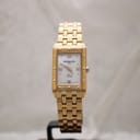 Straight-on front view of the Raymond Weil Tango watch with gold bracelet on a grey background