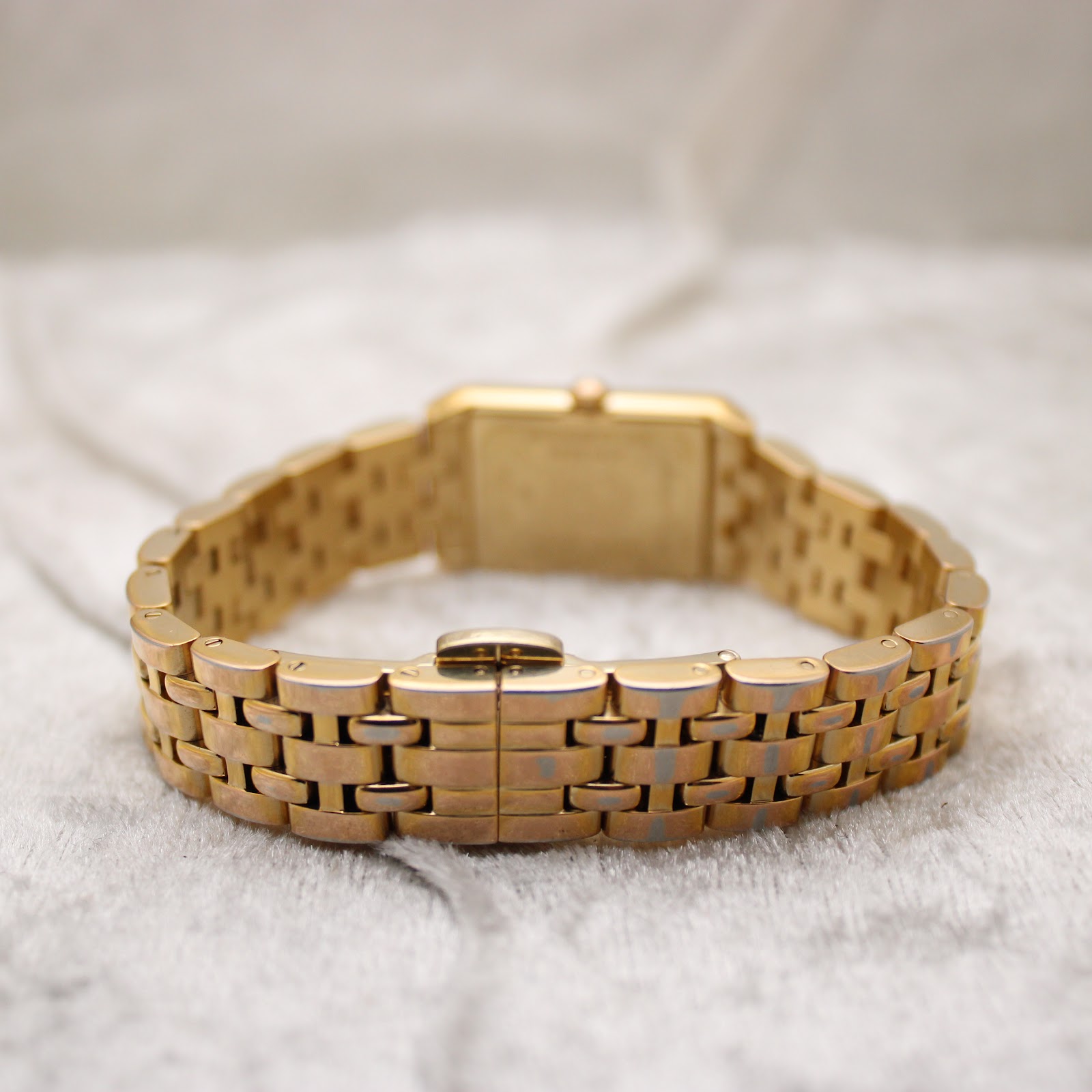 Rear view of the gold watch bracelet with the fold-over deployant clasp mechanism