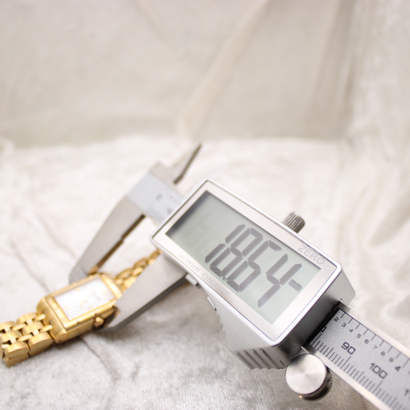 Digital caliper measuring the width of the watch case, displaying a precise measurement of 18.64mm