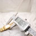 Digital caliper measuring the width of the watch case, displaying a precise measurement of 18.64mm