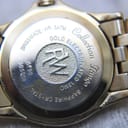 Close-up of the watch case back, detailing 'Swiss Made', 'WR. 5ATM', 'Gold Electroplated 10mc', 'Sapphire Crystal', 'Tango Collection', model '5790', and serial 'V305008'.