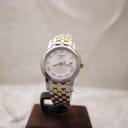 Front view of the Tissot Ballade two-tone watch on a display stand, silver dial with gold Roman numerals.