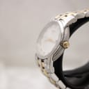 Angled side view of the watch, showing the fluted gold-tone bezel and gold-tone crown details.