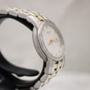 Side profile of the Tissot Ballade watch, showcasing the stainless steel case and gold-tone fluted bezel detail.