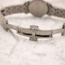 Close-up of the Tissot two-tone stainless steel bracelet with its deployant clasp open, showing interior mechanism.
