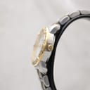 Side view of the Bulova watch case and gold-tone crown on a watch stand.