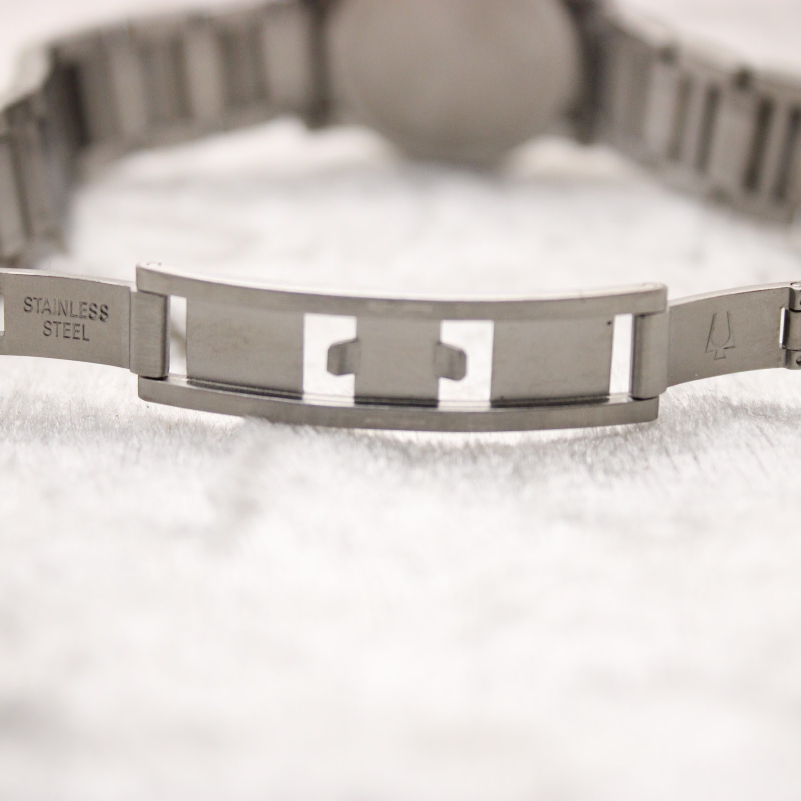 Close-up of the stainless steel folding clasp on the watch bracelet, showing "stainless steel" engraving.