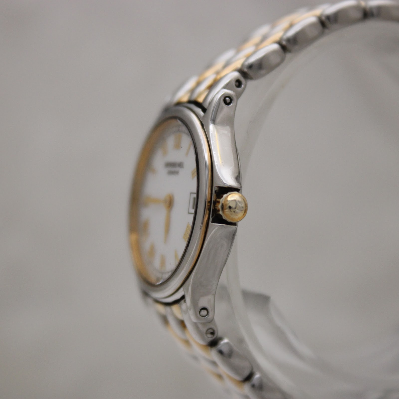 Side view of the Raymond Weil 5377 watch, showing the gold-tone crown and the two-tone bracelet details.