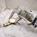 Digital caliper measuring the Bulova watch case diameter, displaying 27.70mm.