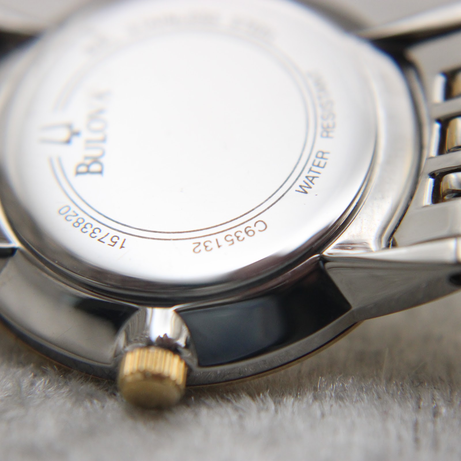 Close-up of the Bulova watch case back, showing model C935132, serial 15733820, and 'Water Resistant' engraving.