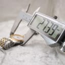 A digital caliper measuring the watch case, displaying an exact diameter of 27.39mm on a light background.