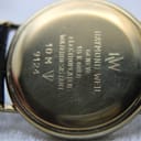 Close-up of the polished gold-plated case back, engraved with "RW RAYMOND WEIL GENEVE", "18 K GOLD ELECTROPLATED", "10 M WATER RESISTANT", and "9124".