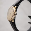 Right side view of the Raymond Weil watch showing the fluted bezel and gold-tone crown with a dark cabochon.