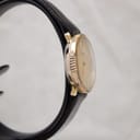 Left side view of the Raymond Weil watch showing the fluted bezel and the slim profile of the gold-tone case.
