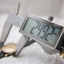 Digital caliper display showing a measurement of 24.92mm, measuring the watch case diameter.