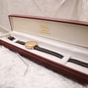 The Raymond Weil watch resting inside a dark red presentation box from "Mays Jewellers".
