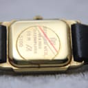 Close-up of the watch's case back, engraved with "Raymond Weil Genève", "18 K GOLD ELECTROPLATED", "10 M", and "5700", showing slight wear.