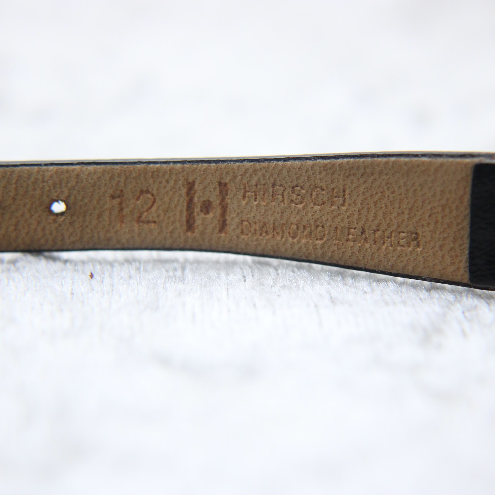 Close-up of the underside of the black leather strap, embossed with "12" and "HIRSCH DIAMOND LEATHER", indicating the lug width and strap type.