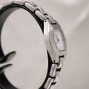 Angled side view of the Tissot G333 watch on a stand, highlighting the polished finish of the stainless steel case and bracelet.