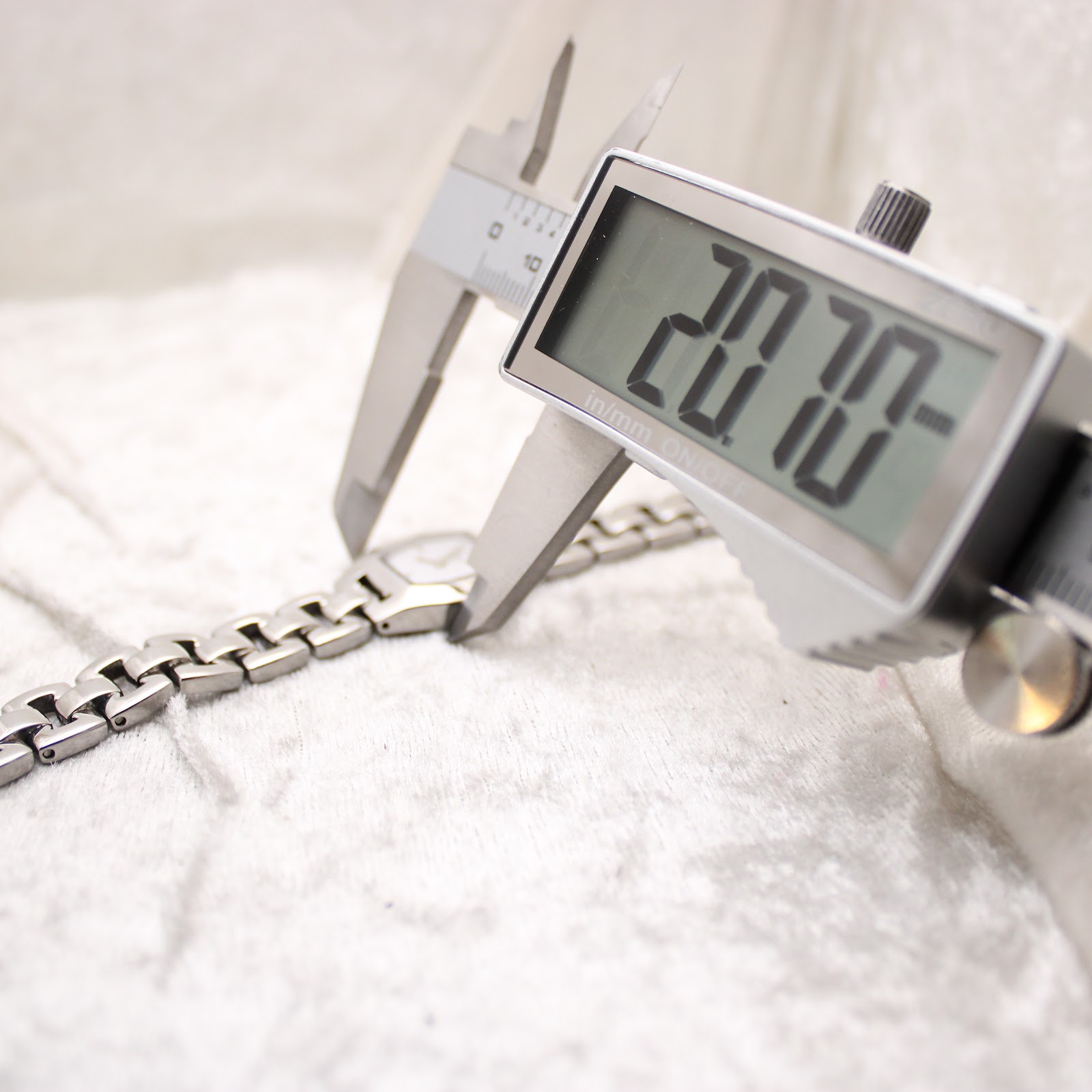 Digital caliper measuring the case diameter of the Tissot G333, displaying a precise reading of 20.70 mm.