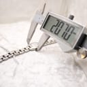 Digital caliper measuring the case diameter of the Tissot G333, displaying a precise reading of 20.70 mm.