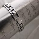 Close-up of the Tissot G333 stainless steel bracelet clasp on a wrist sizing gauge, showing a measurement around 172-175 mm (17.2-17.5 cm).
