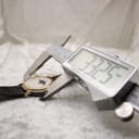 Close-up of a digital caliper measuring the watch case diameter, displaying 33.25mm.