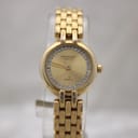 Front view of Raymond Weil ladies' gold watch with crystal-set dial on a watch stand.