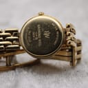 Close-up of the watch case back, showing 'Raymond Weil', model 5806-2, '18K Gold Electroplated', and 'Water Resistant' engravings.