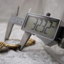 Digital caliper measuring the case diameter of the gold Raymond Weil watch, displaying 20.09mm.