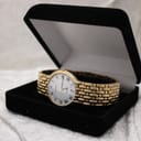 The gold watch bracelet on a wrist sizing gauge, indicating a wrist circumference of approximately 16.5 cm.