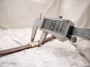 Digital caliper measuring the width of the Raymond Weil watch case from a different angle, displaying an exact measurement of 19.11 mm.