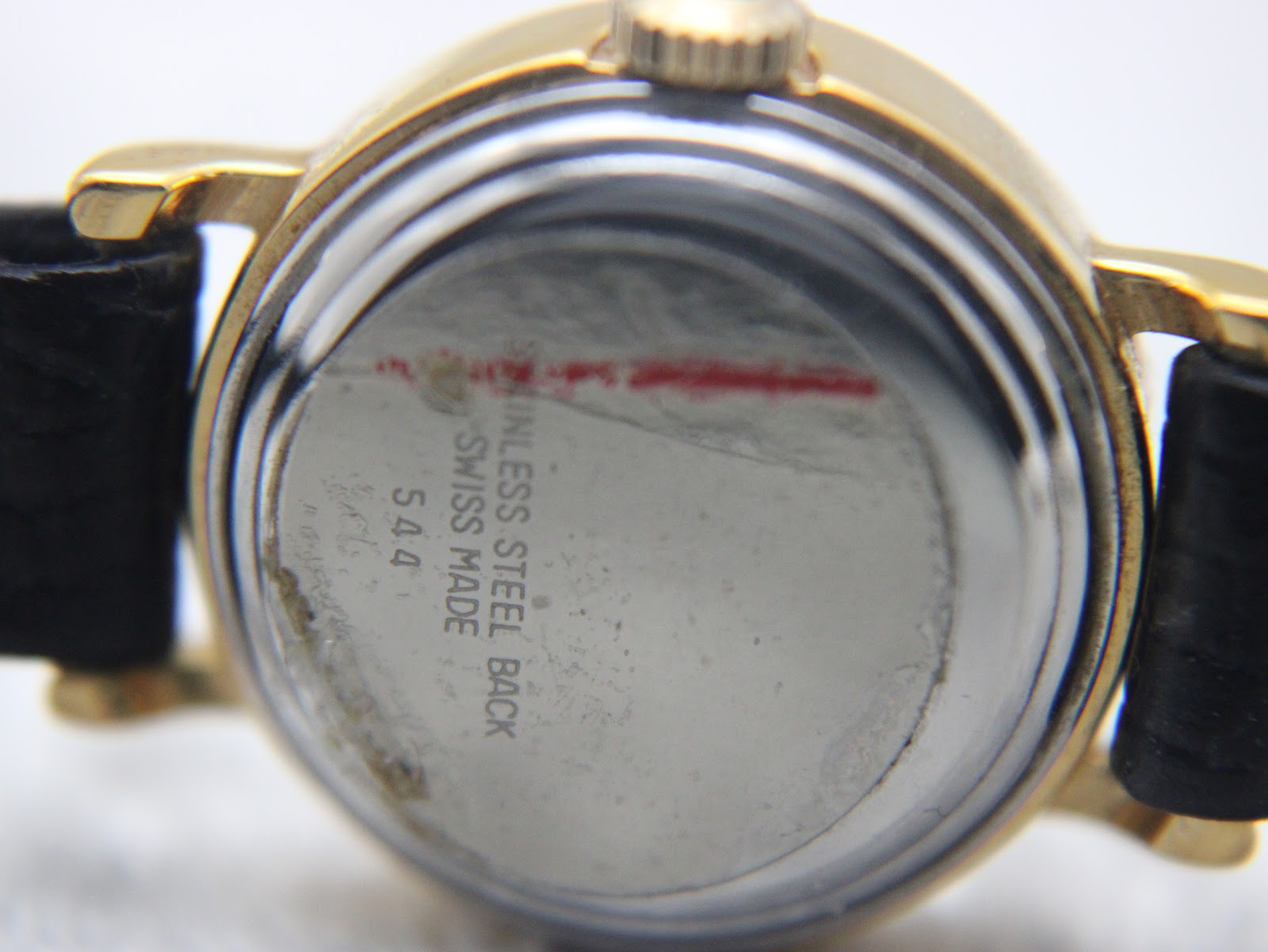 Close-up of the stainless steel case back of the Raymond Weil watch, showing 'stainless steel back' and '544'.