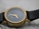 Close-up of the watch dial and gold case bezel from a slightly different angle, showing the ridged texture of the bezel.