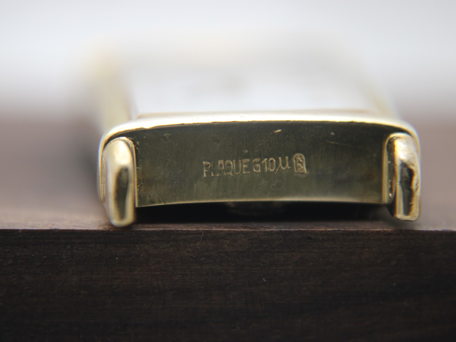 Close-up of the lug area on the underside of the watch, showing "PLAQUE G 10µ" engraving