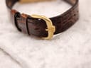 Close-up of the gold-plated buckle with "RW" logo on the brown crocodile leather strap