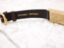 Close-up of the underside of the brown crocodile leather strap showing "CROCODILE VERITABLE" embossing