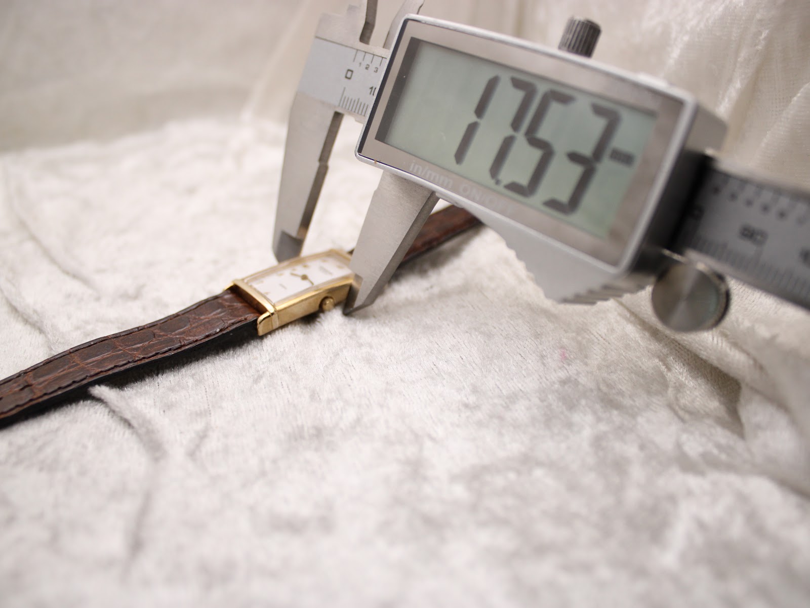 Digital caliper measuring the width of the watch case, displaying 17.53 mm