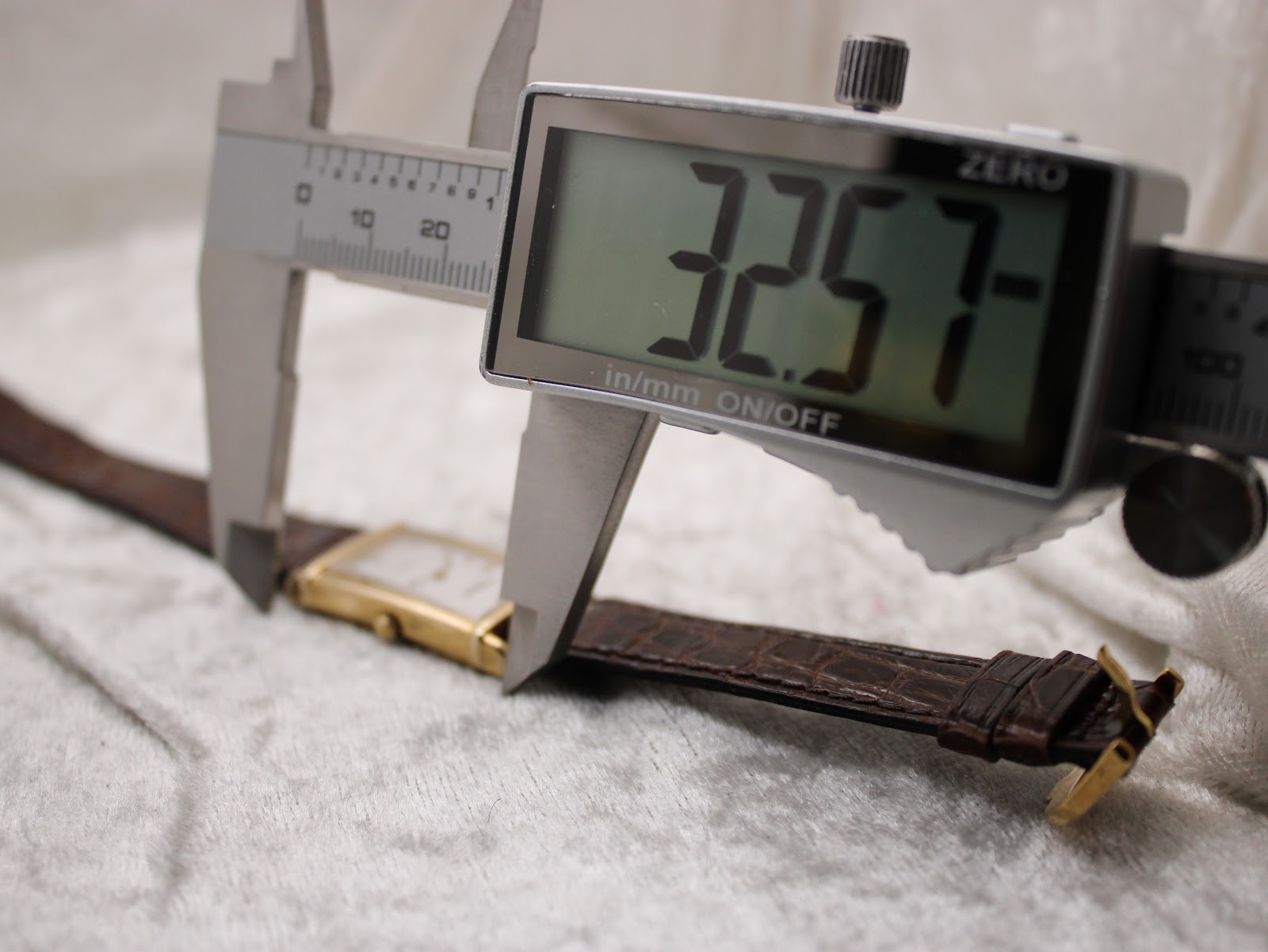 Digital caliper measuring the length of the watch case, displaying 32.57 mm