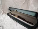 Full view of the Raymond Weil watch inside an open dark green watch presentation box with light interior