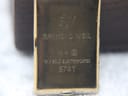 Close-up of the watch case back showing "RW", "RAYMOND WEIL", "10 M", "18 K GOLD ELECTROPLATED", and "5741" engravings