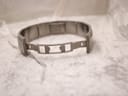Underside view of the stainless steel greca bracelet with its deployment clasp open.