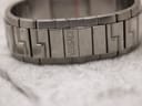 Close-up of the bracelet showing 'VERSACE' engraved on a link and the distinctive greca pattern.