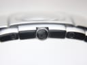 Extreme close-up of the Medusa head logo engraved on the watch's crown.